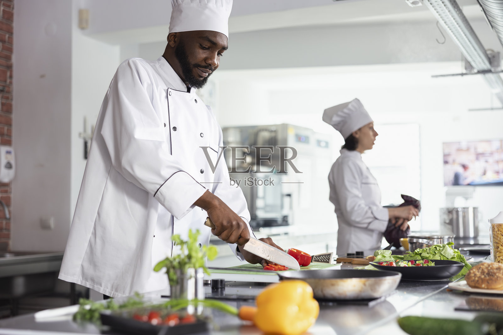 黑人主厨在现代工作空间中切新鲜的甜椒照片摄影图片