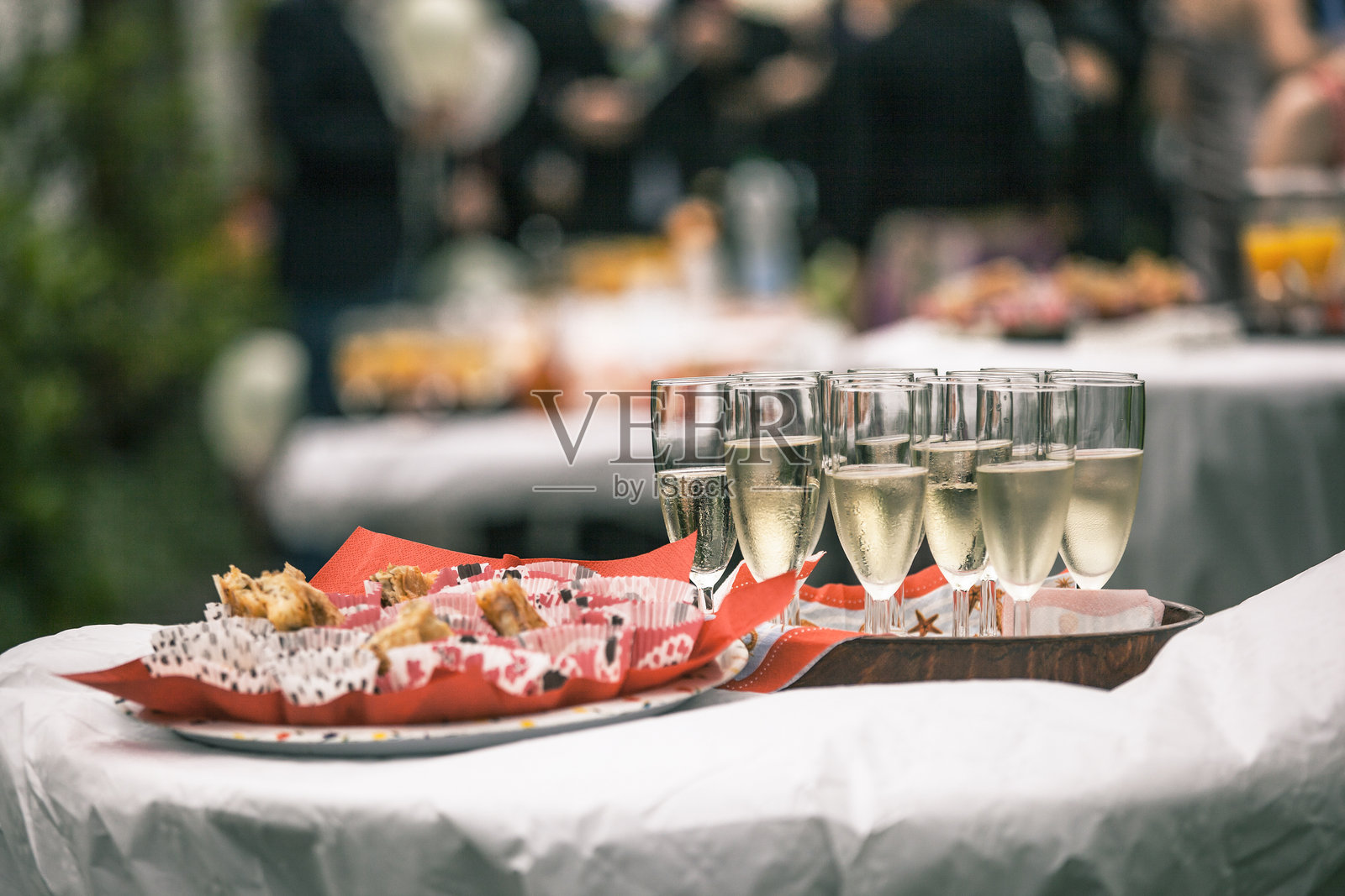 优雅的户外聚会,庆祝活动中桌上摆放着香槟杯和开胃菜照片摄影图片