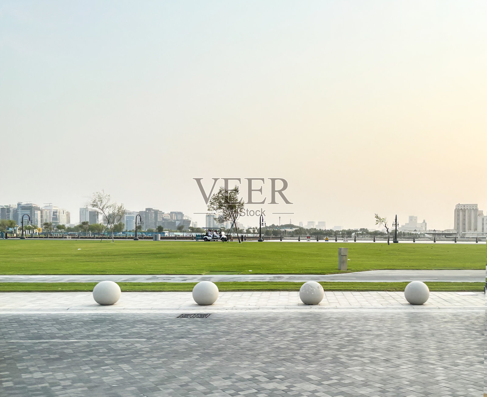 一个干净现代的公园,广阔的绿草坪与多哈的城市天际线相映成趣。照片摄影图片