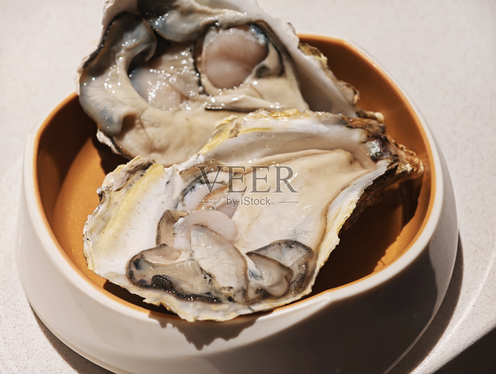 碗中盛放着两只生蚝的特写镜头照片摄影图片