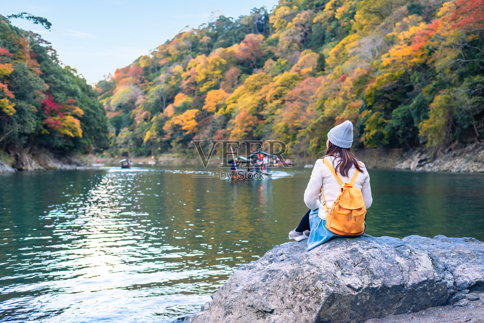 年轻女性旅行者在日本京都的岚山放松,欣赏秋叶的美丽,旅行生活方式概念照片摄影图片