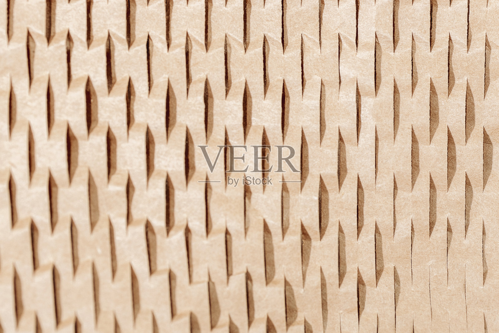 特写的棕色波纹纸板,带有几何切割图案,抽象的包装材料背景照片摄影图片