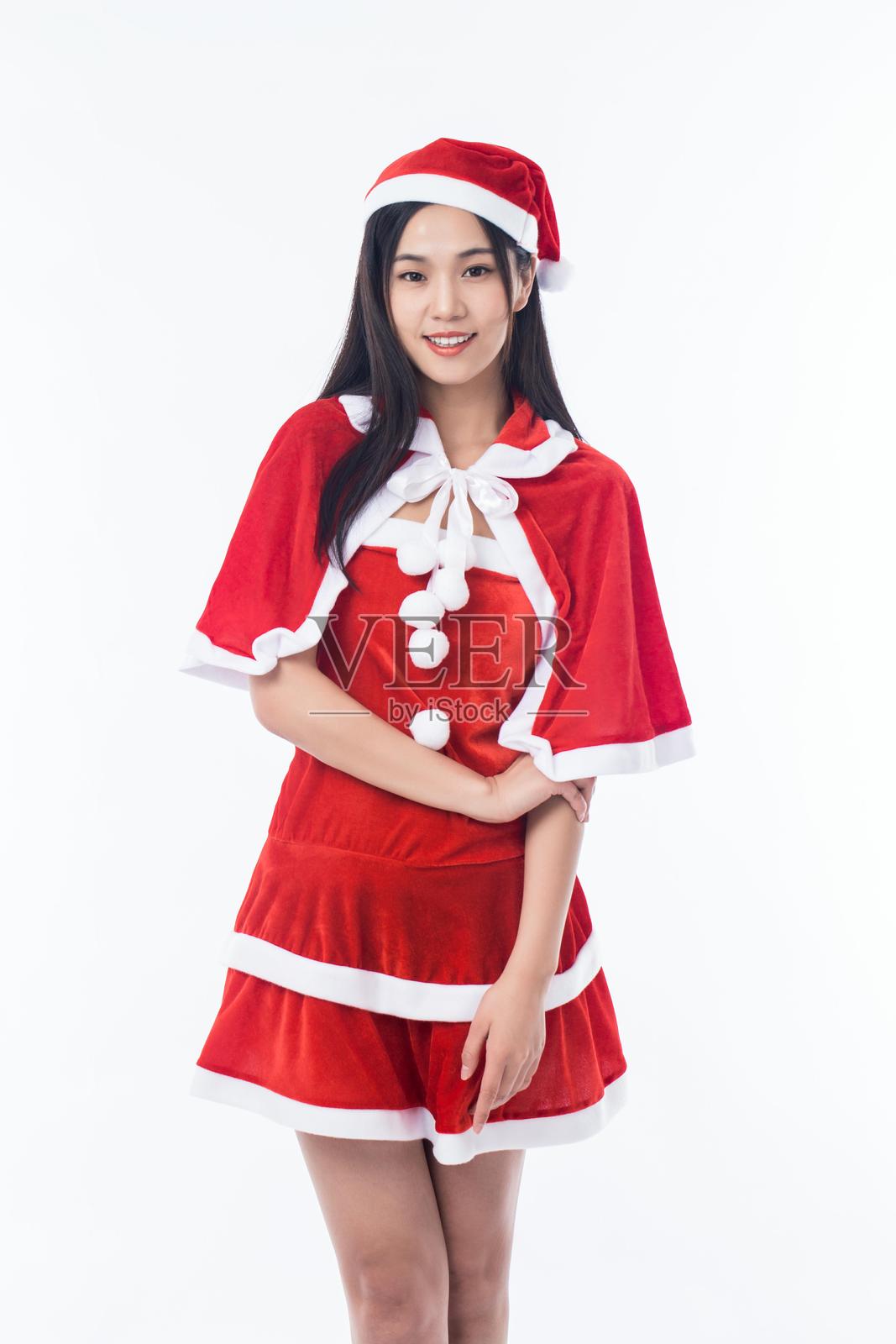 年轻的亚洲女性穿着圣诞服装,站在白色背景前照片摄影图片