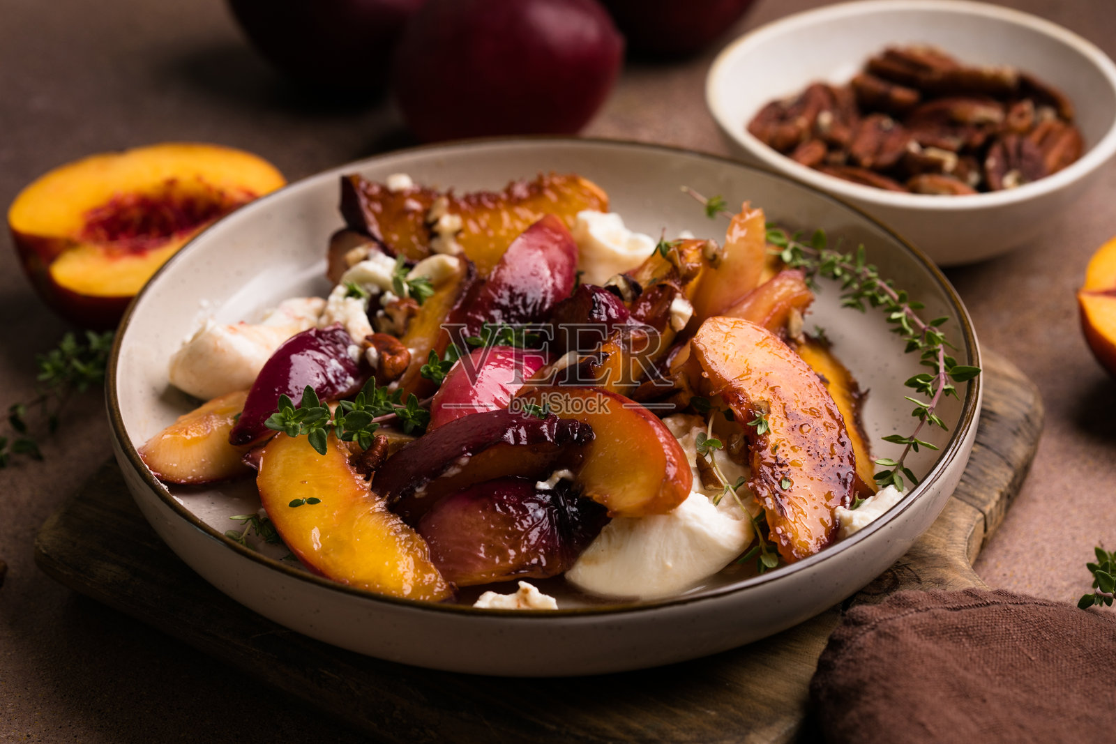 焦糖桃子、意大利奶酪、胡桃、百里香和蜂蜜沙拉照片摄影图片