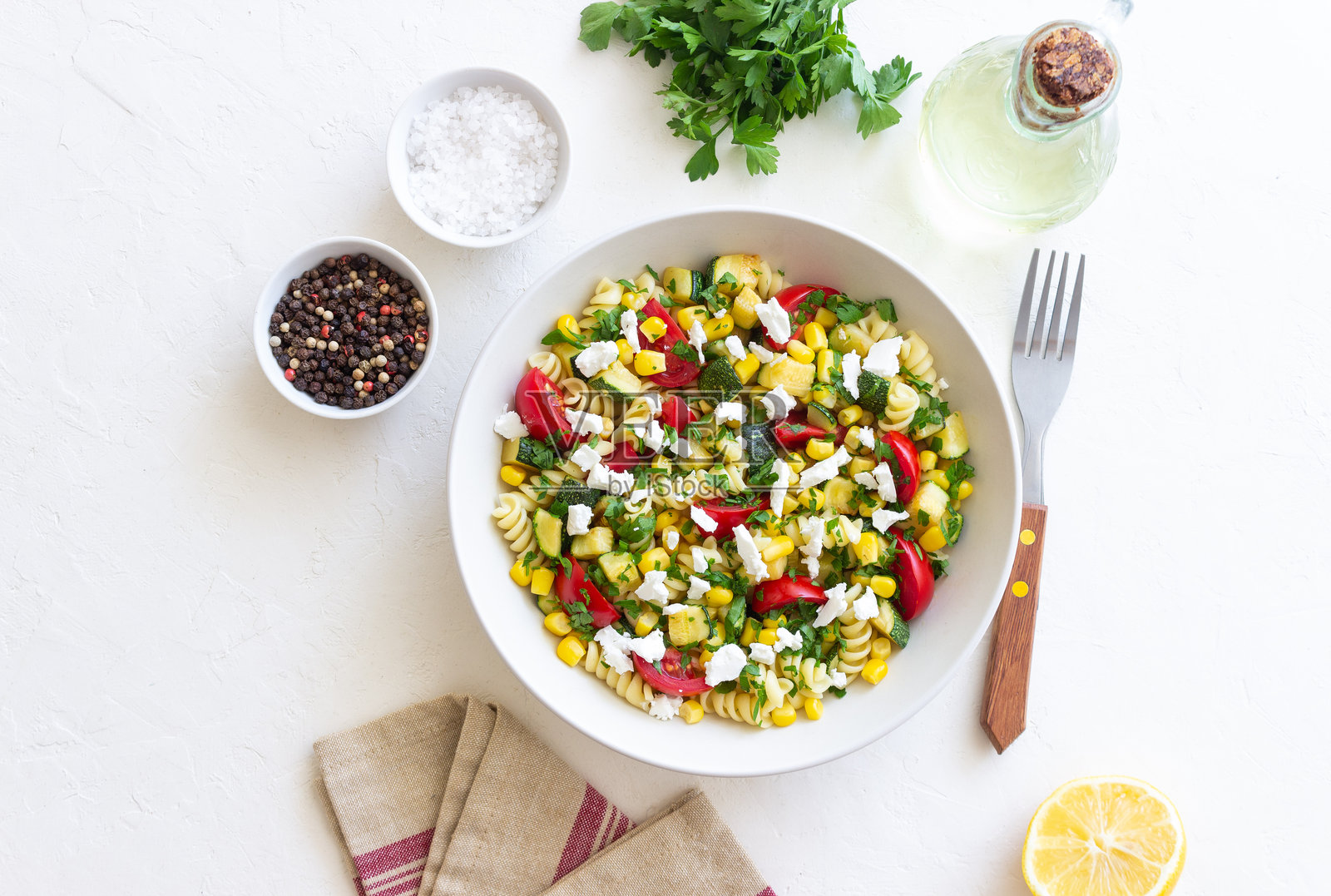 番茄、 zucchini、玉米和羊奶酪的意大利面沙拉。健康饮食。素食。照片摄影图片
