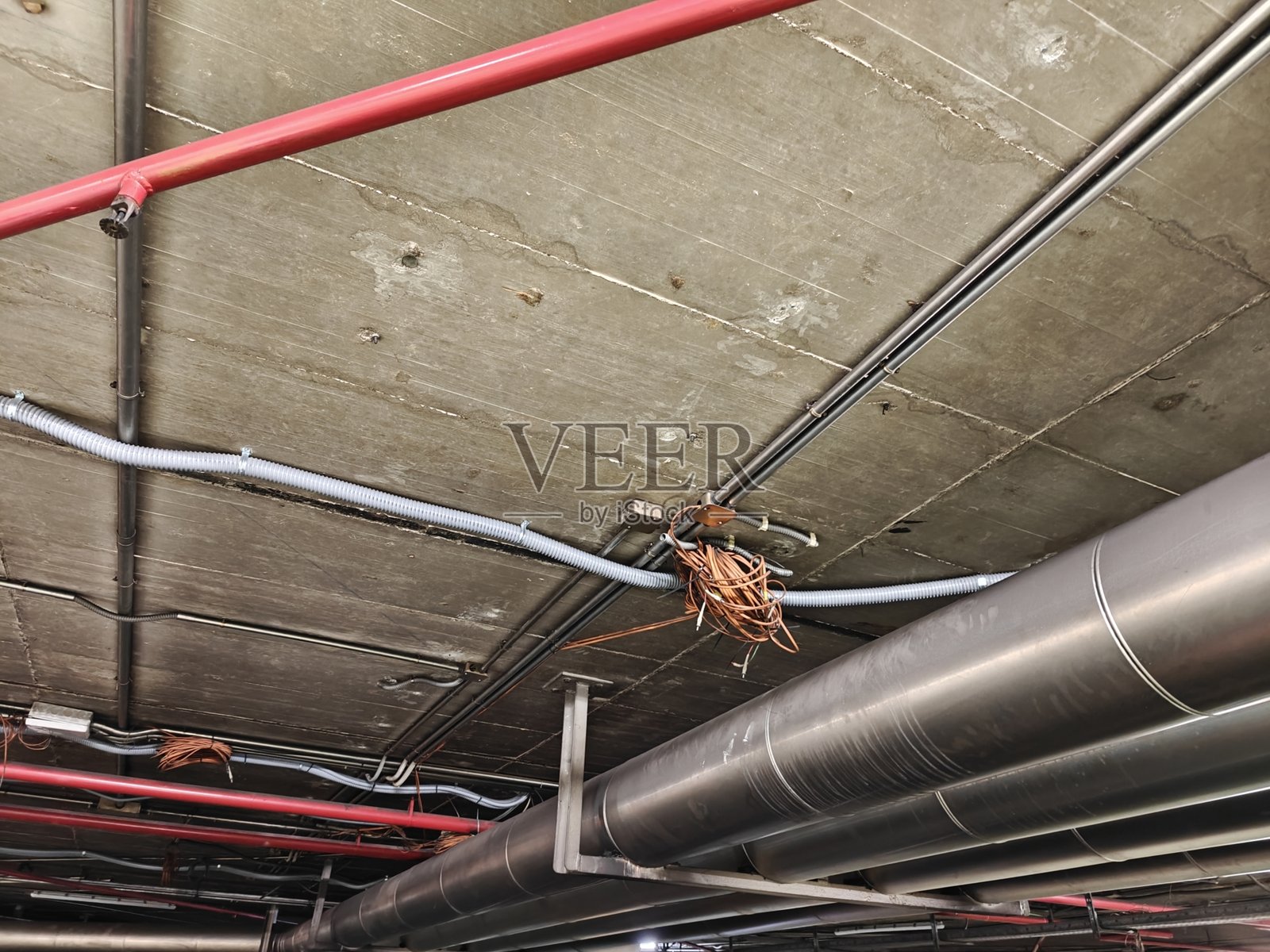 车库天花板上的电缆和管道。照片摄影图片