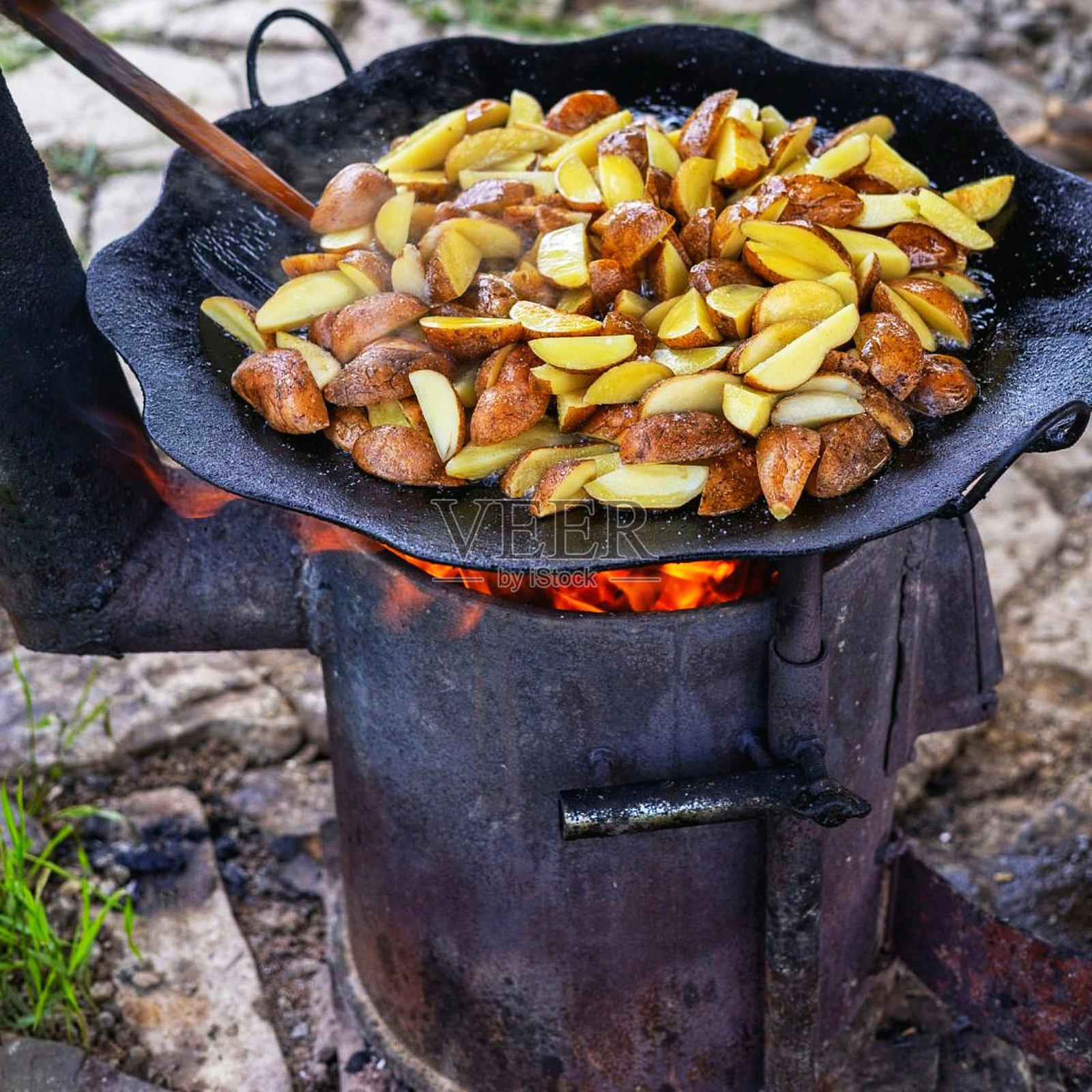 户外炉灶上炸土豆照片摄影图片