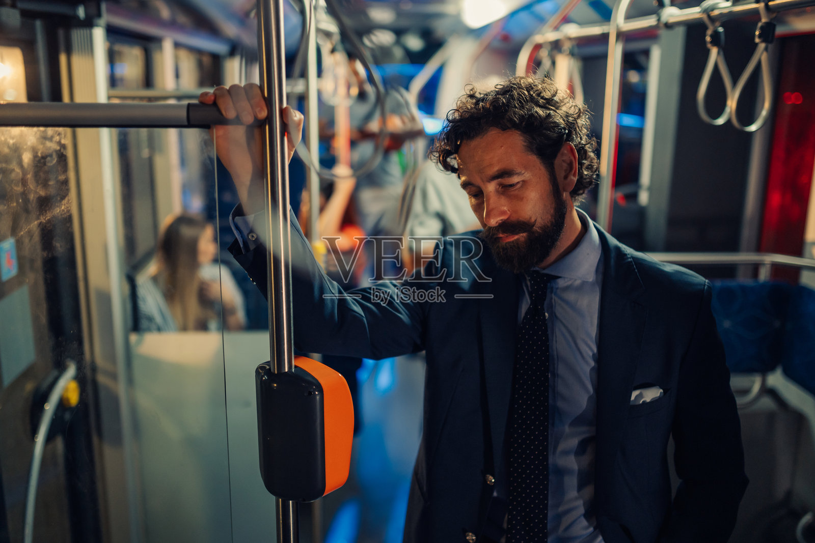 疲惫的商人在夜晚拥挤的公交车上站着照片摄影图片