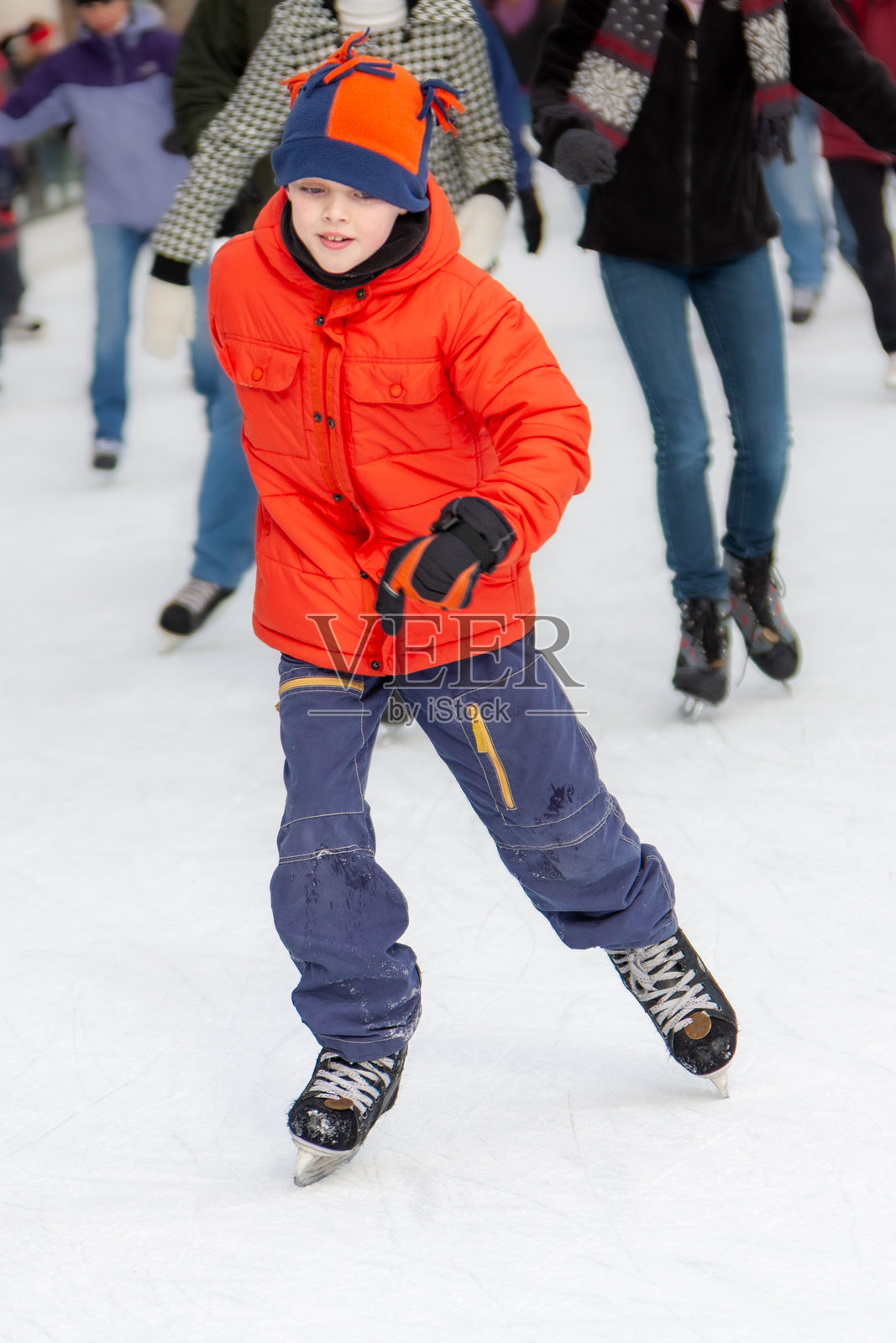 男孩在芝加哥千禧公园户外滑冰的正面视图。照片摄影图片