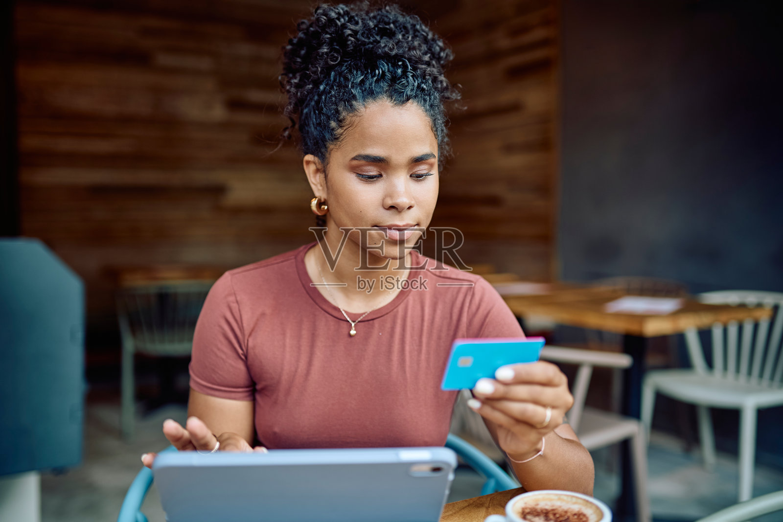 年轻女性在咖啡馆使用平板电脑和信用卡进行在线支付照片摄影图片