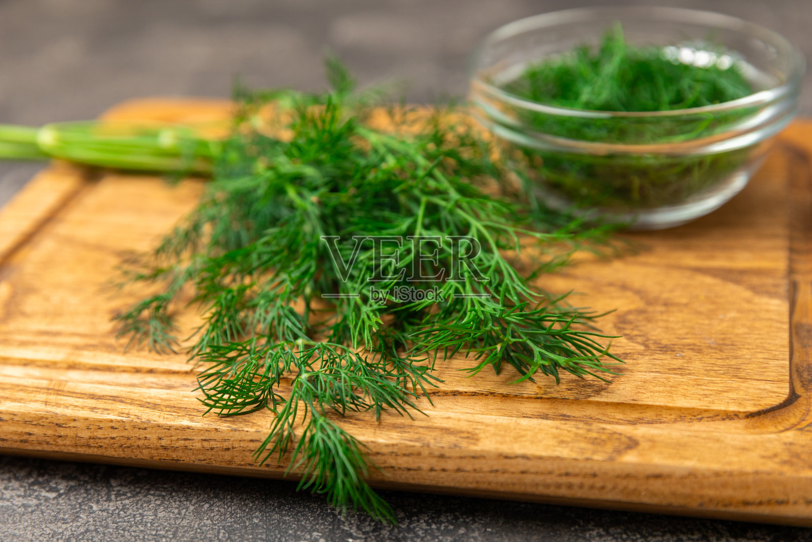 木质背景上的莳萝。新鲜有机绿叶。莳萝种植。切好的莳萝叶。春季嫩莳萝束。维生素。纤维。芳香的烹饪香料。留白区域。照片摄影图片