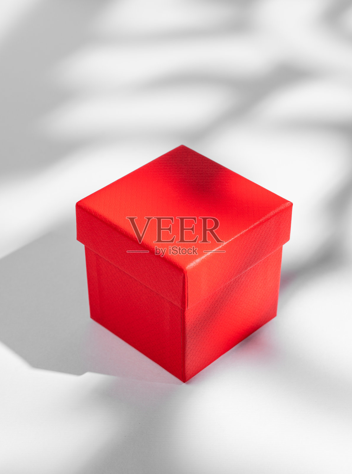 白色背景上的红色礼盒,带有柔和的阴影。节日礼物的概念。照片摄影图片