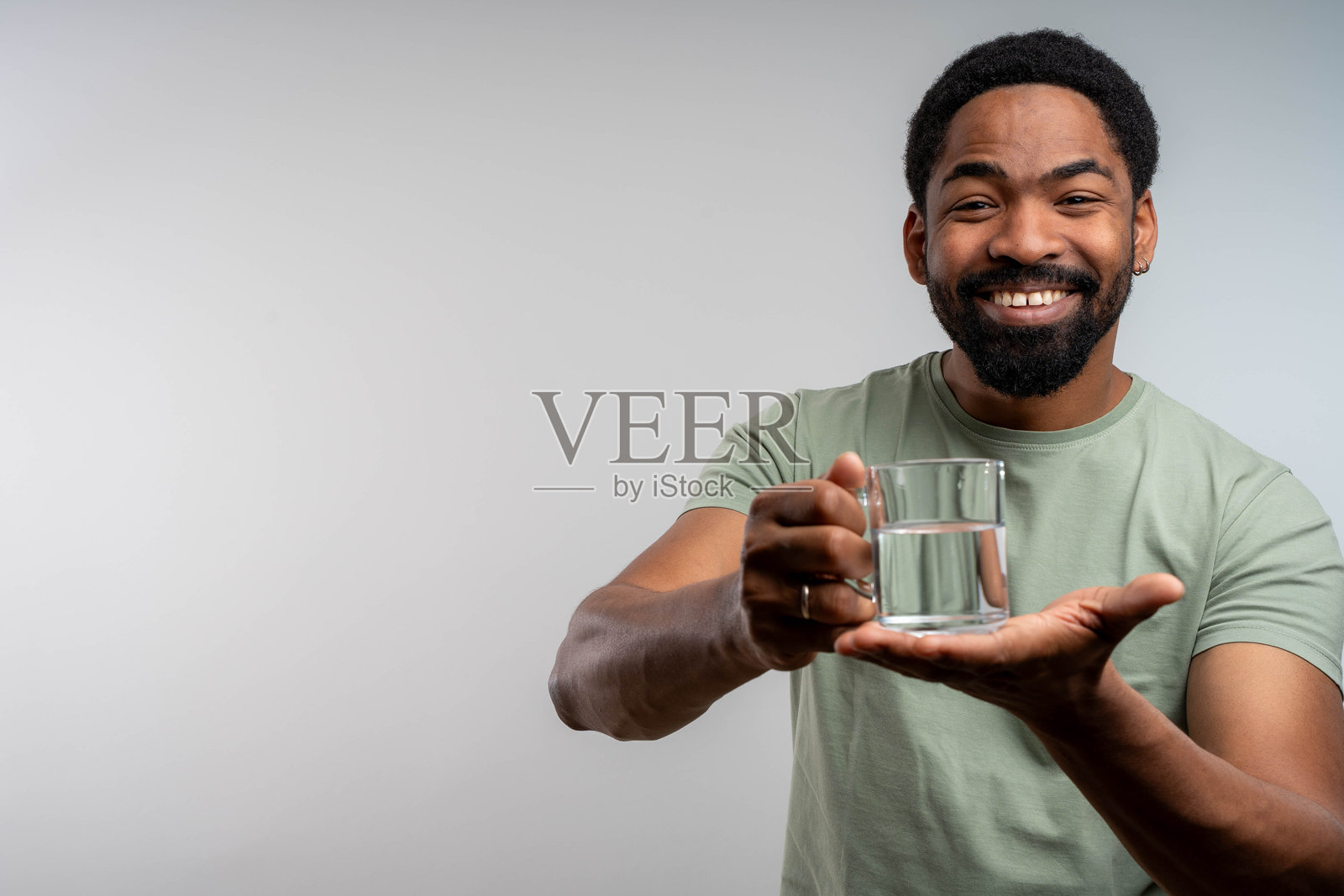 微笑的非洲男子手持一杯水,背景孤立并留有空白空间照片摄影图片