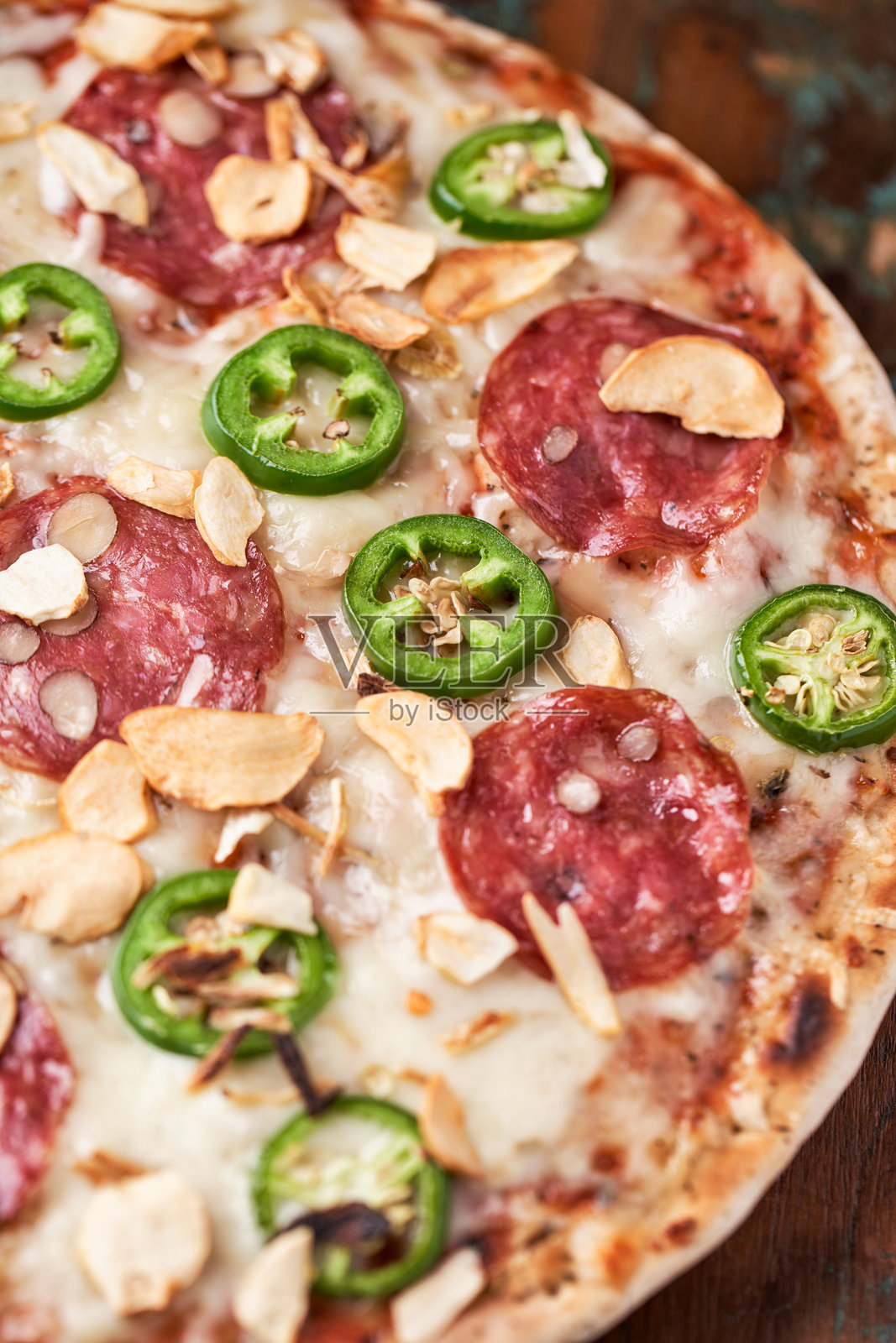 意大利香肠、马苏里拉奶酪和墨西哥胡椒的比萨饼。木质背景。柔和的焦点。照片摄影图片