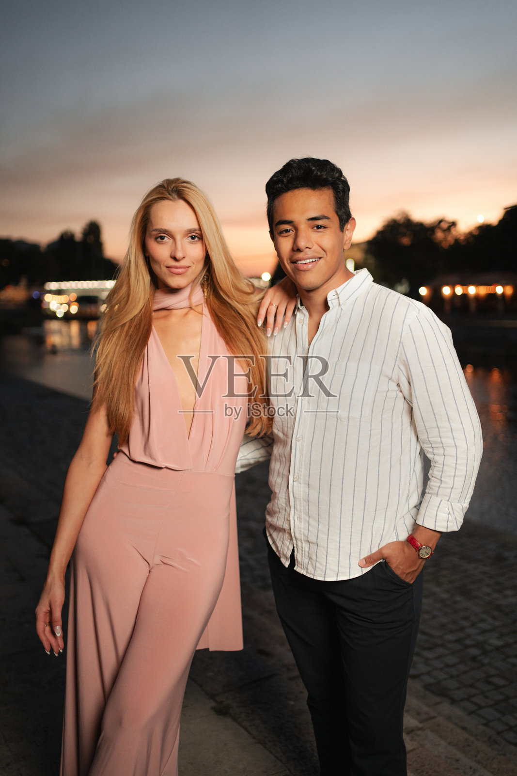 年轻情侣在巴黎塞纳河畔黄昏时分摆姿势照片摄影图片