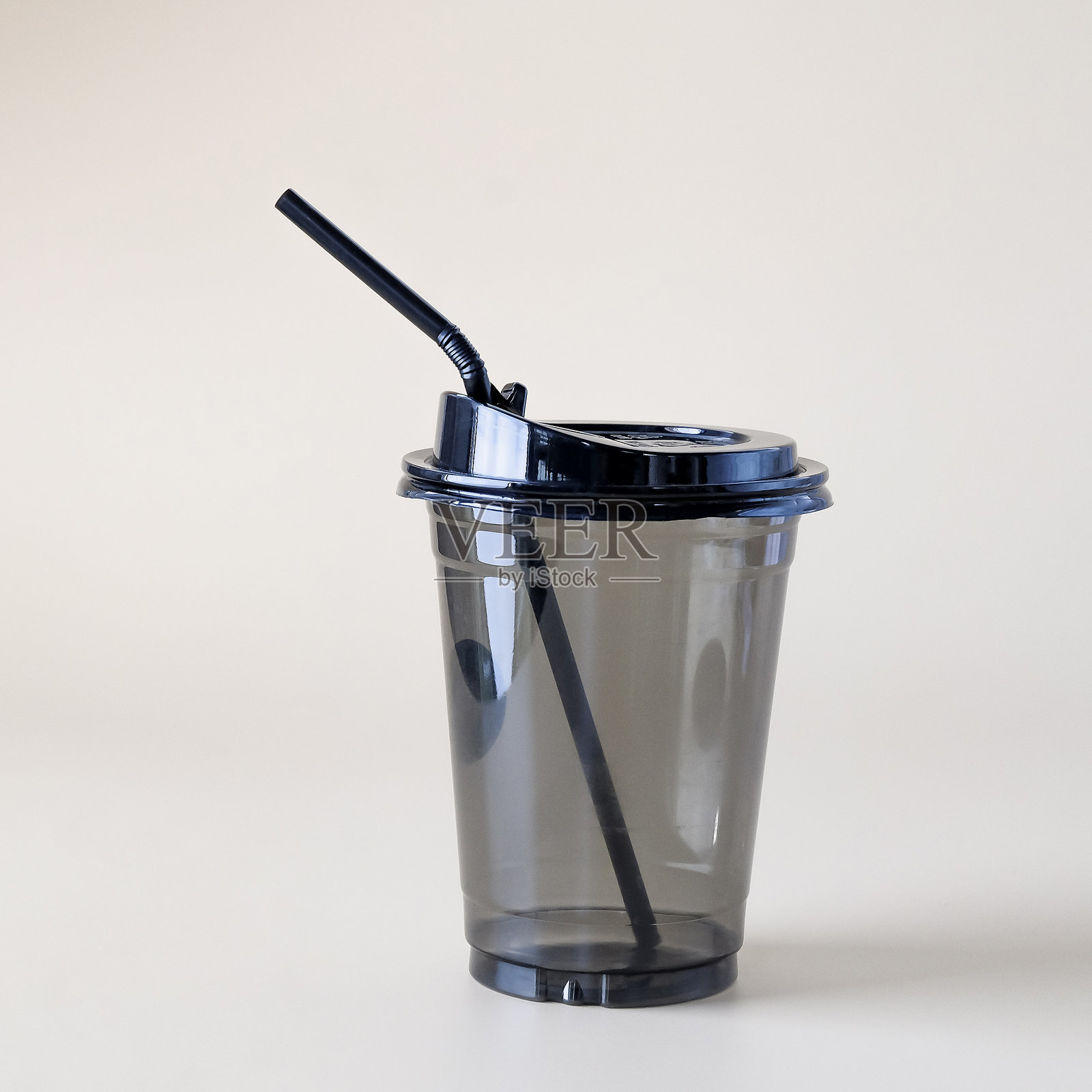 黑色封闭塑料杯置于彩色背景上。照片摄影图片