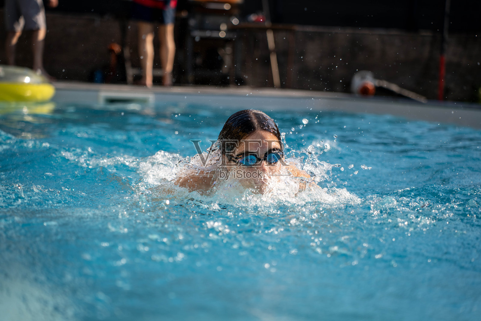 年轻女性在游泳池中训练,练习游泳技巧。照片摄影图片