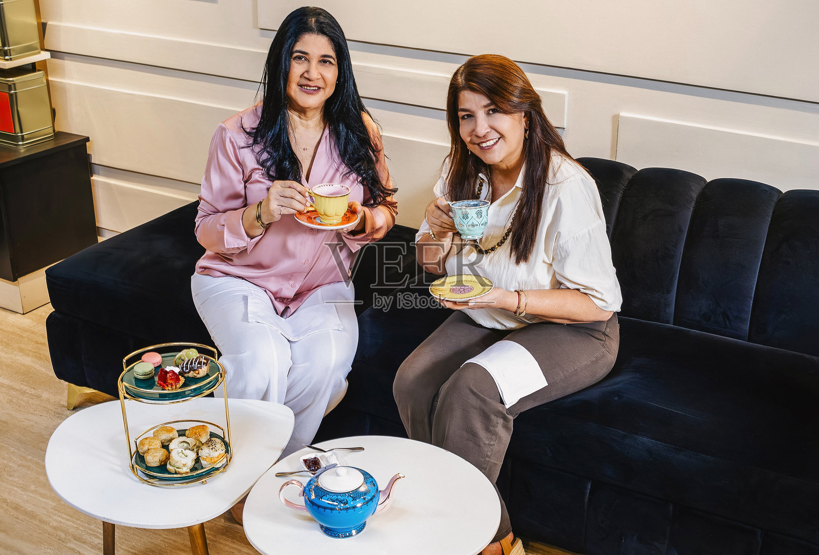 两位微笑的女商人在她们的茶馆享受茶歇时光照片摄影图片