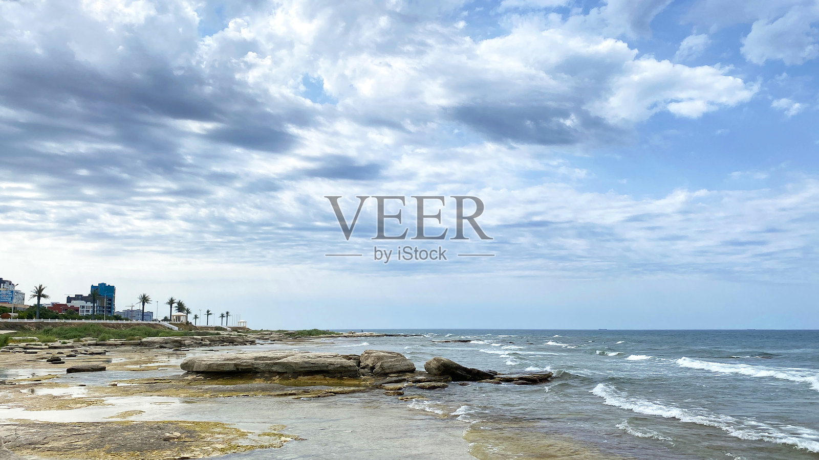 哈萨克斯坦阿克套海滨小镇的堤岸景观。里海。一个有岩石海岸线和多云天空的海滩。照片摄影图片