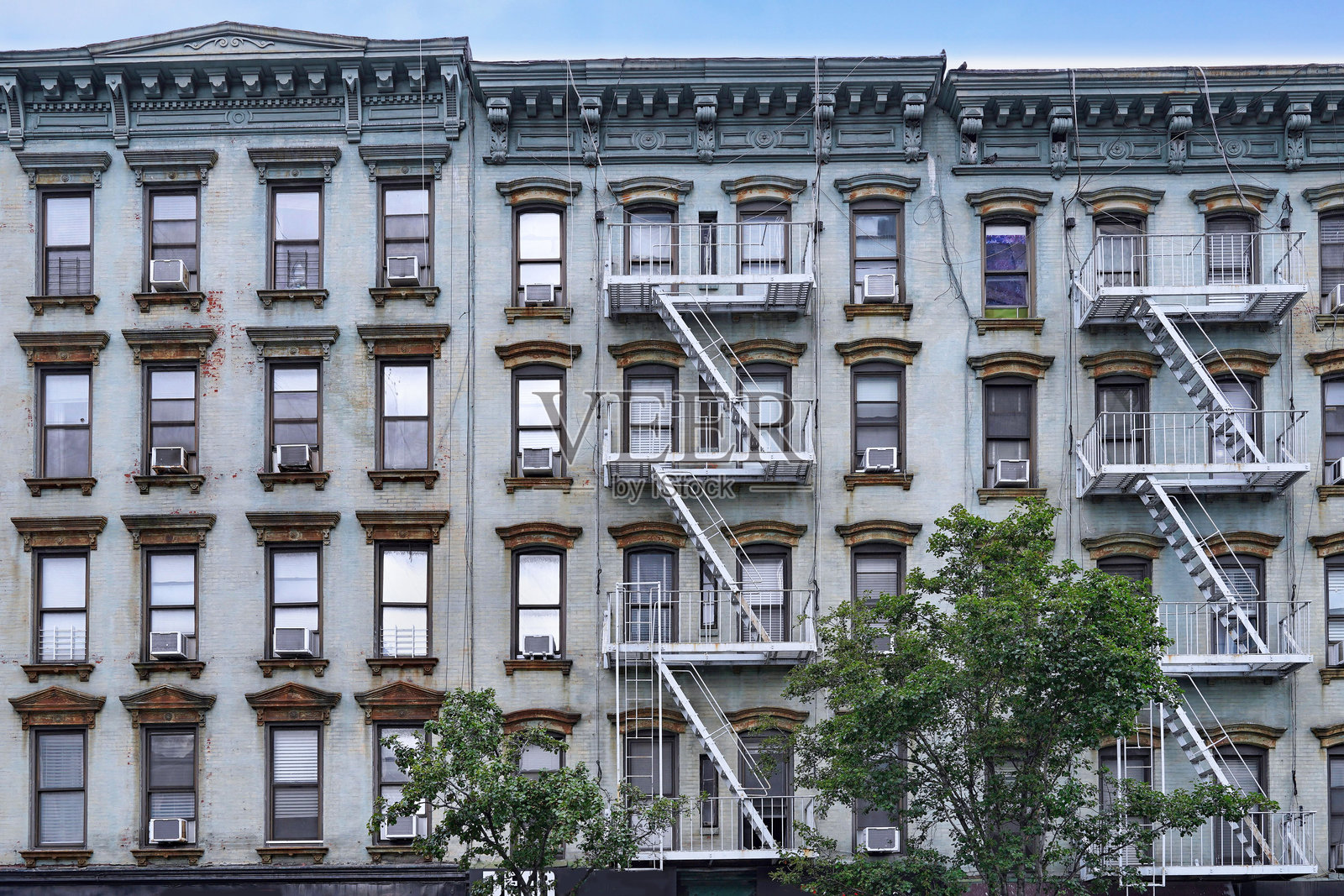 旧纽约公寓楼,外部有消防逃生梯和生锈的窗台。照片摄影图片