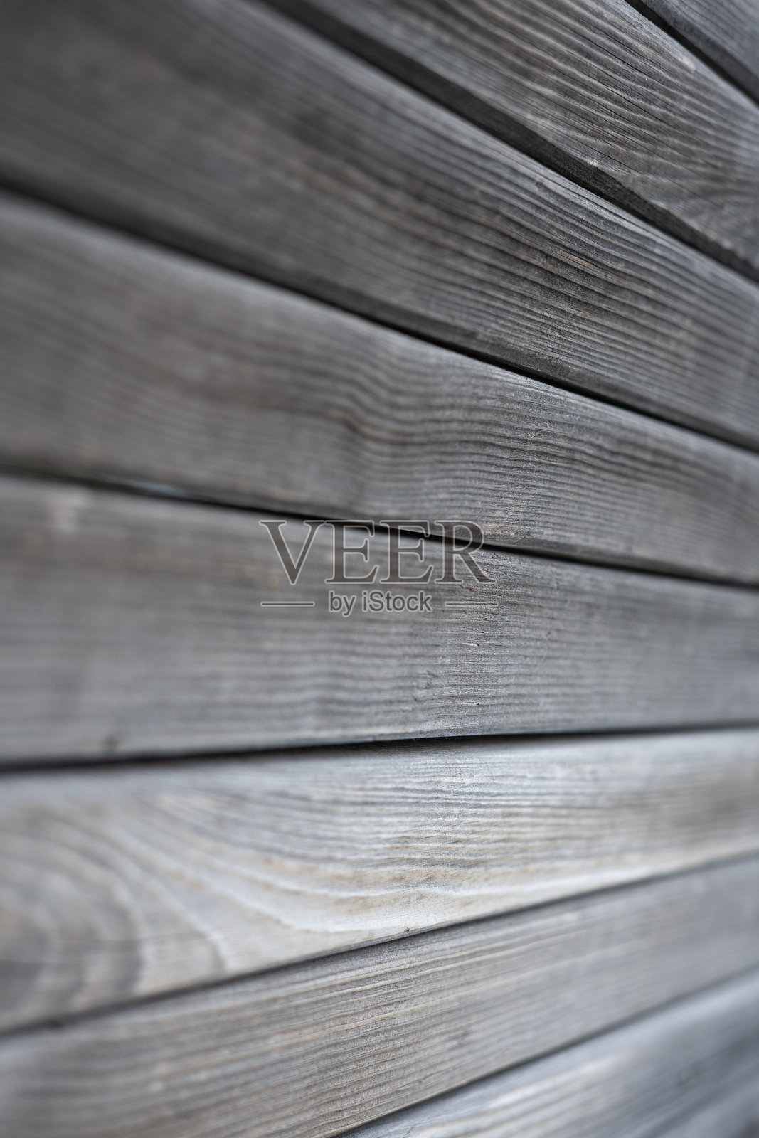 特写视角下的纹理木材表面,展示了带有自然纹理和风化外观的水平木板。照片摄影图片