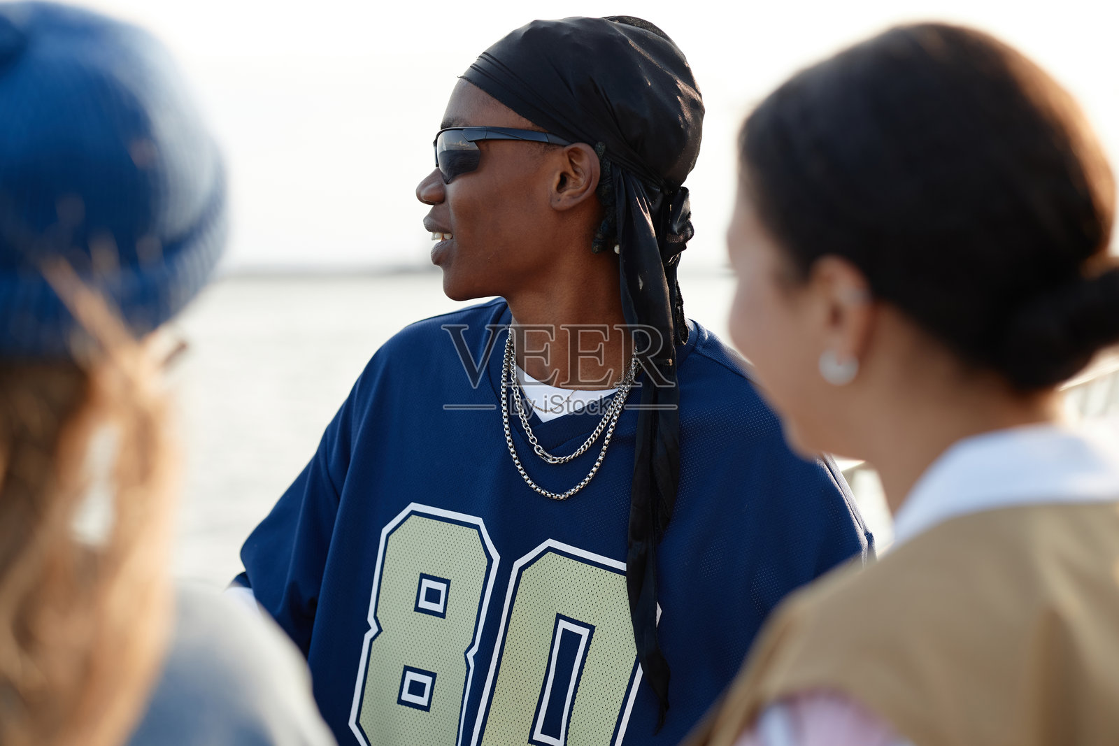 年轻的黑人男性戴着太阳镜与朋友们在户外社交照片摄影图片