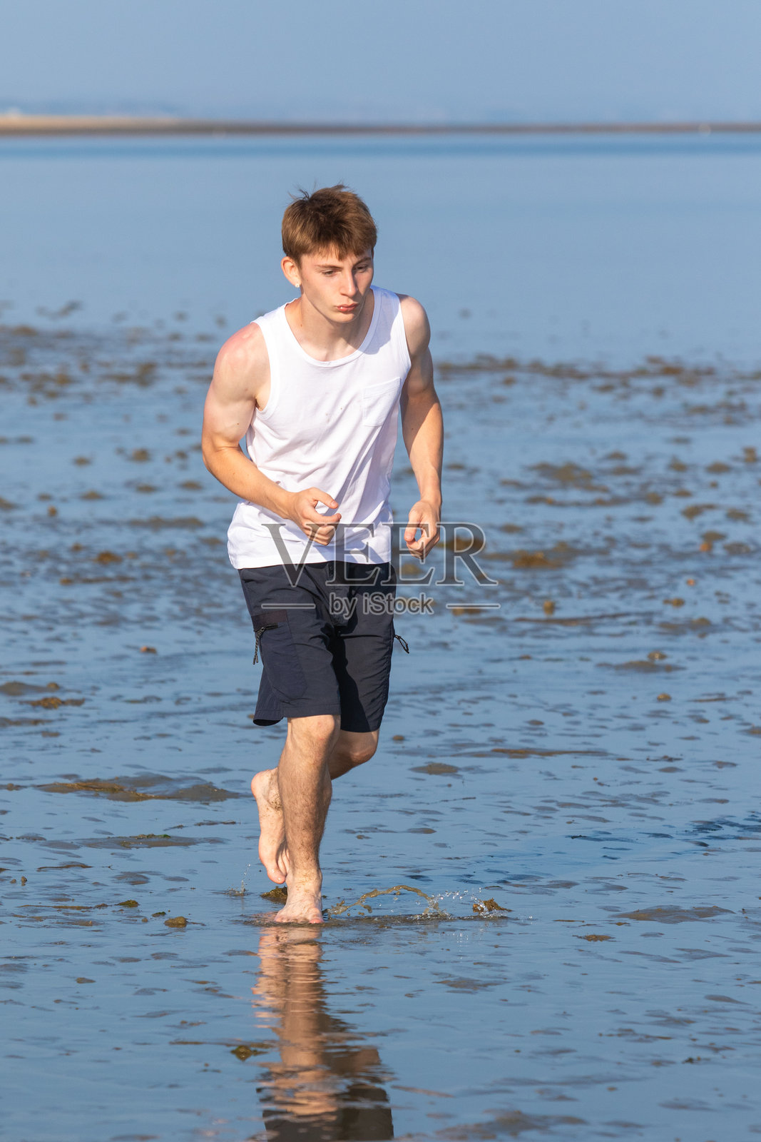 少年在海岸边奔跑照片摄影图片