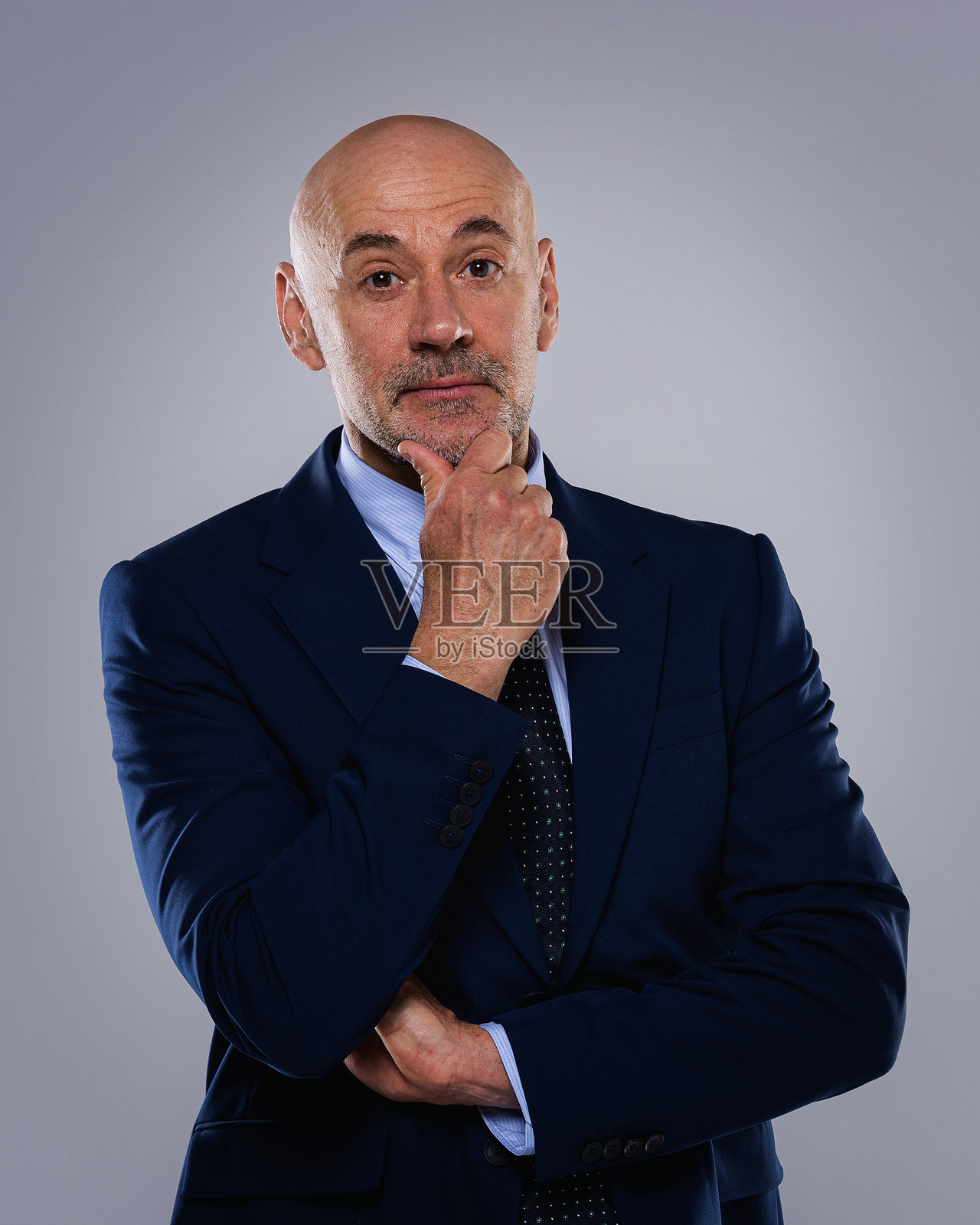 资深商人的工作室肖像,背景为纯色。照片摄影图片