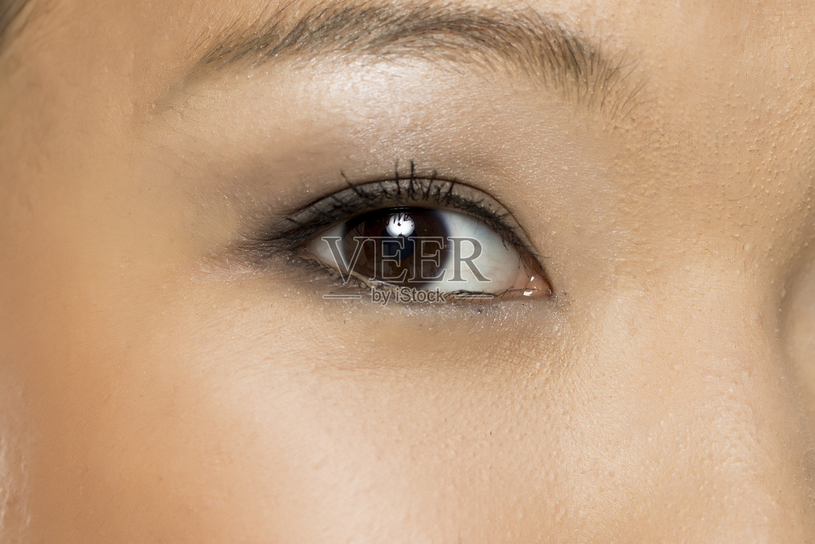 女性眼睛的特写,化妆效果明显,展示皮肤纹理和睫毛,白色背景下的摄影作品。照片摄影图片