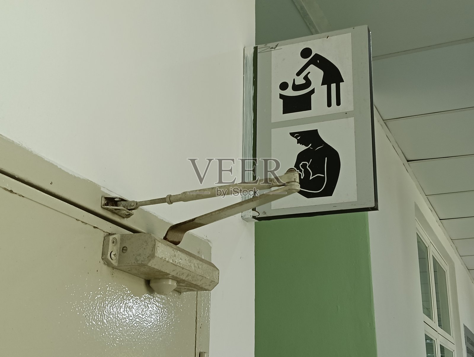 马来西亚一栋建筑内房间入口处的母乳喂养和女性儿童护理标志照片摄影图片