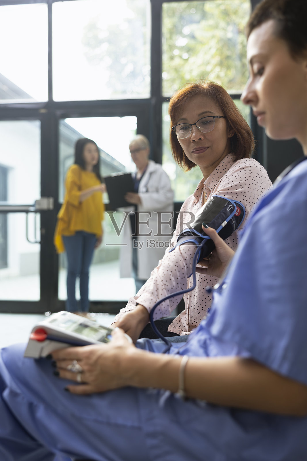 护士在例行检查中使用数字血压监测仪测量血压照片摄影图片