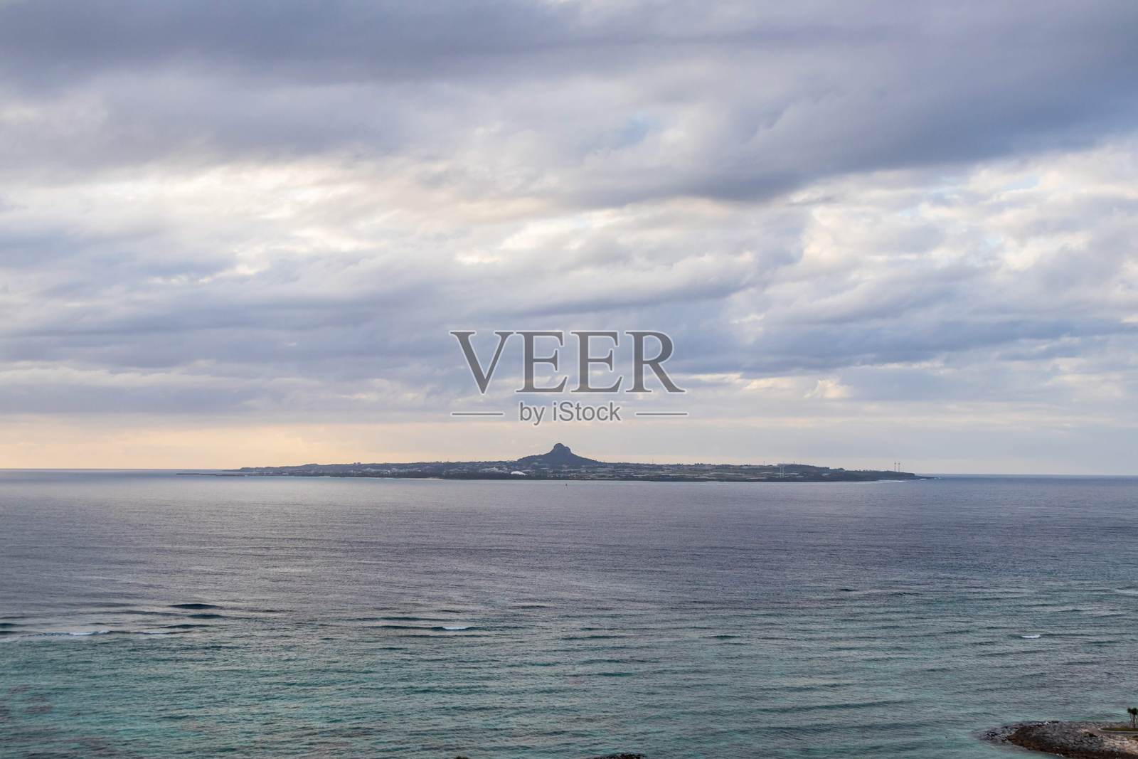 日本冲绳的古城山与海岸水域日落景色照片摄影图片