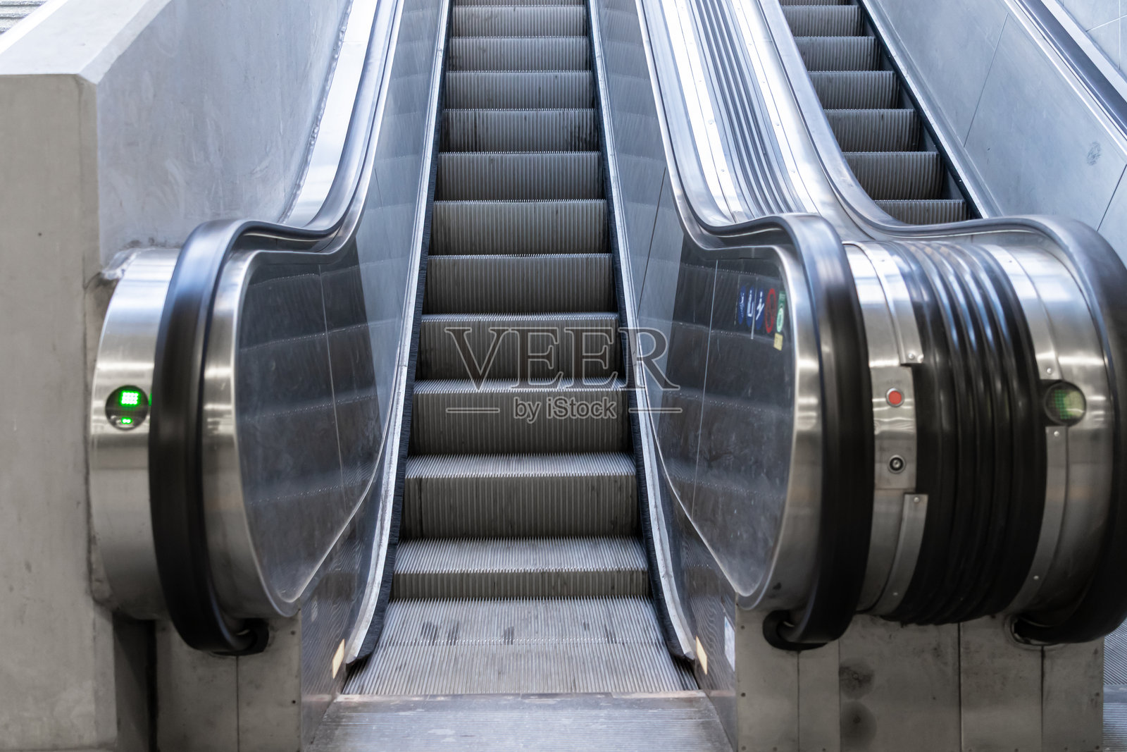 现代电梯配有抛光金属台阶和明亮的扶手,在简约的公共空间中平稳上升,象征着城市的增长和向上的流动性。照片摄影图片