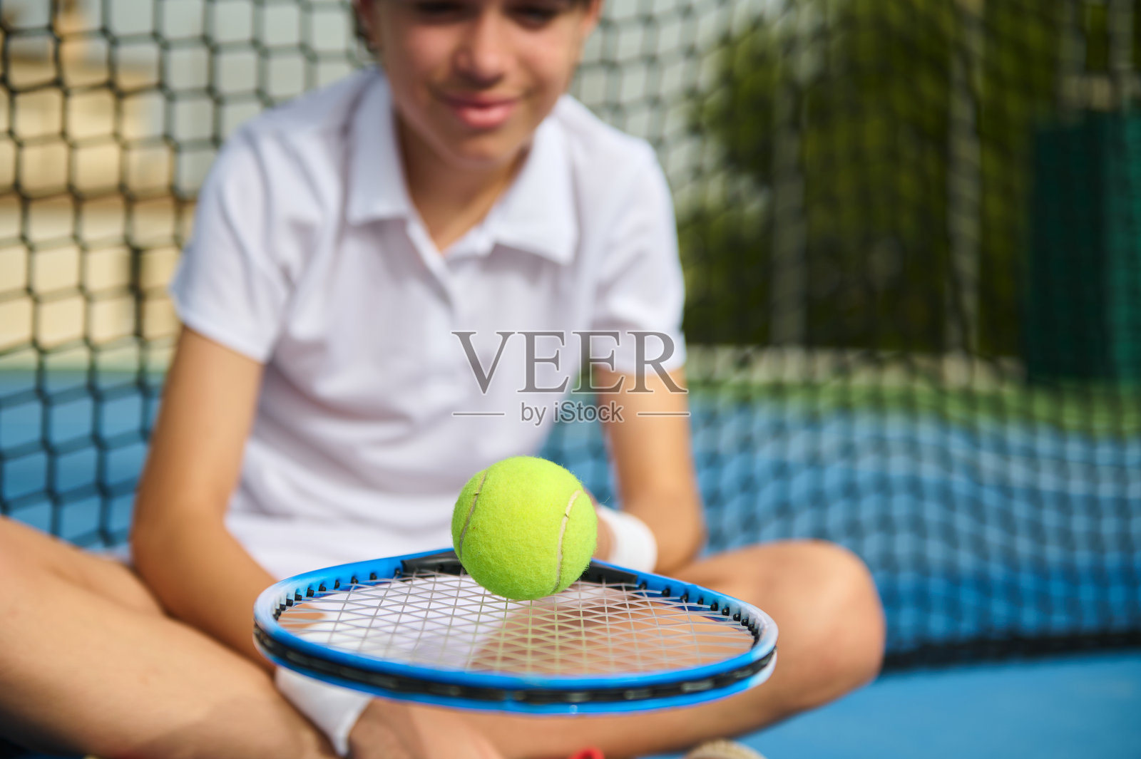 年轻的网球运动员在球场上手持球拍和网球照片摄影图片