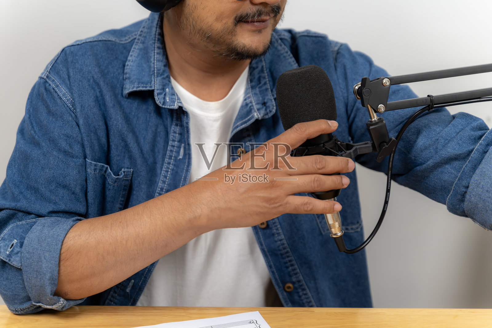 年轻男子在家用麦克风和笔记本电脑录制播客照片摄影图片