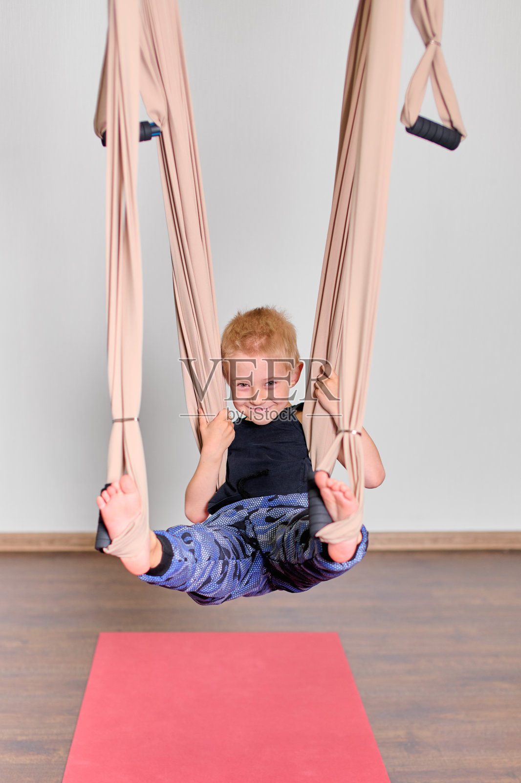 年轻男孩在空中吊床上快乐地玩耍照片摄影图片