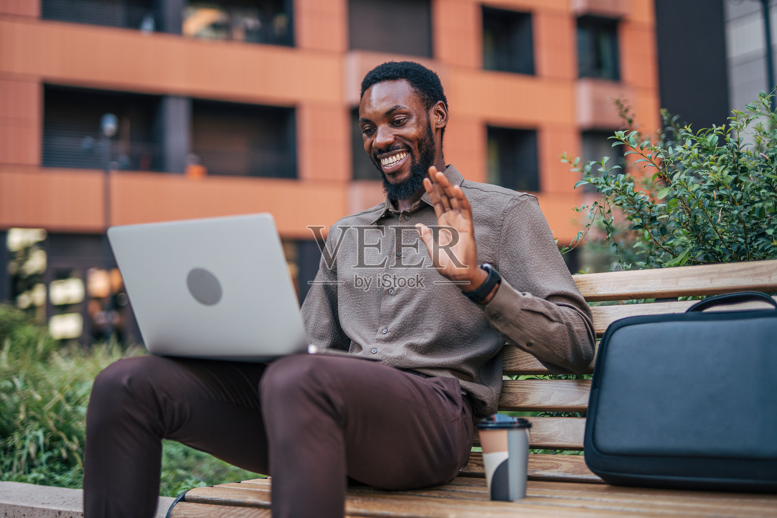 城市环境中通过笔记本电脑进行视频会议的商人照片摄影图片