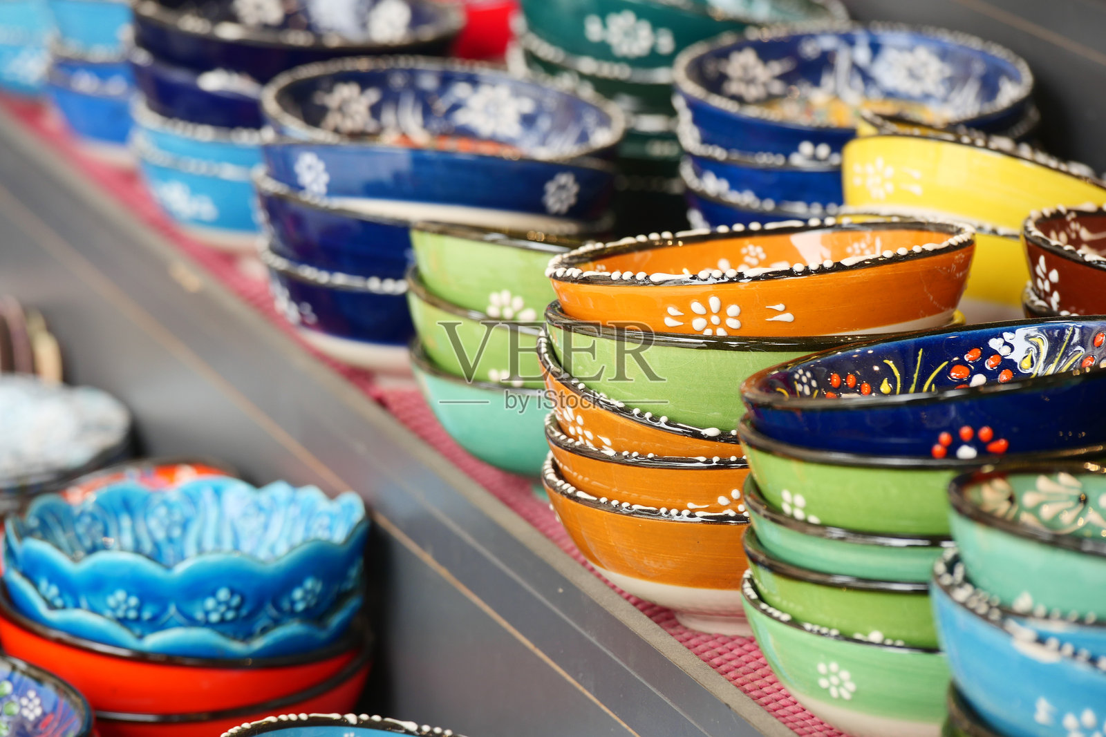 市场摊位上展示的五彩手工陶瓷碗照片摄影图片
