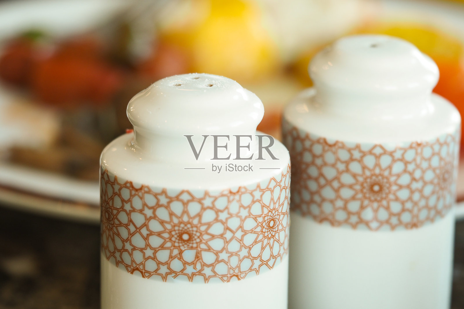 桌子上放着盐和胡椒瓶,旁边是一道新鲜准备的菜肴照片摄影图片