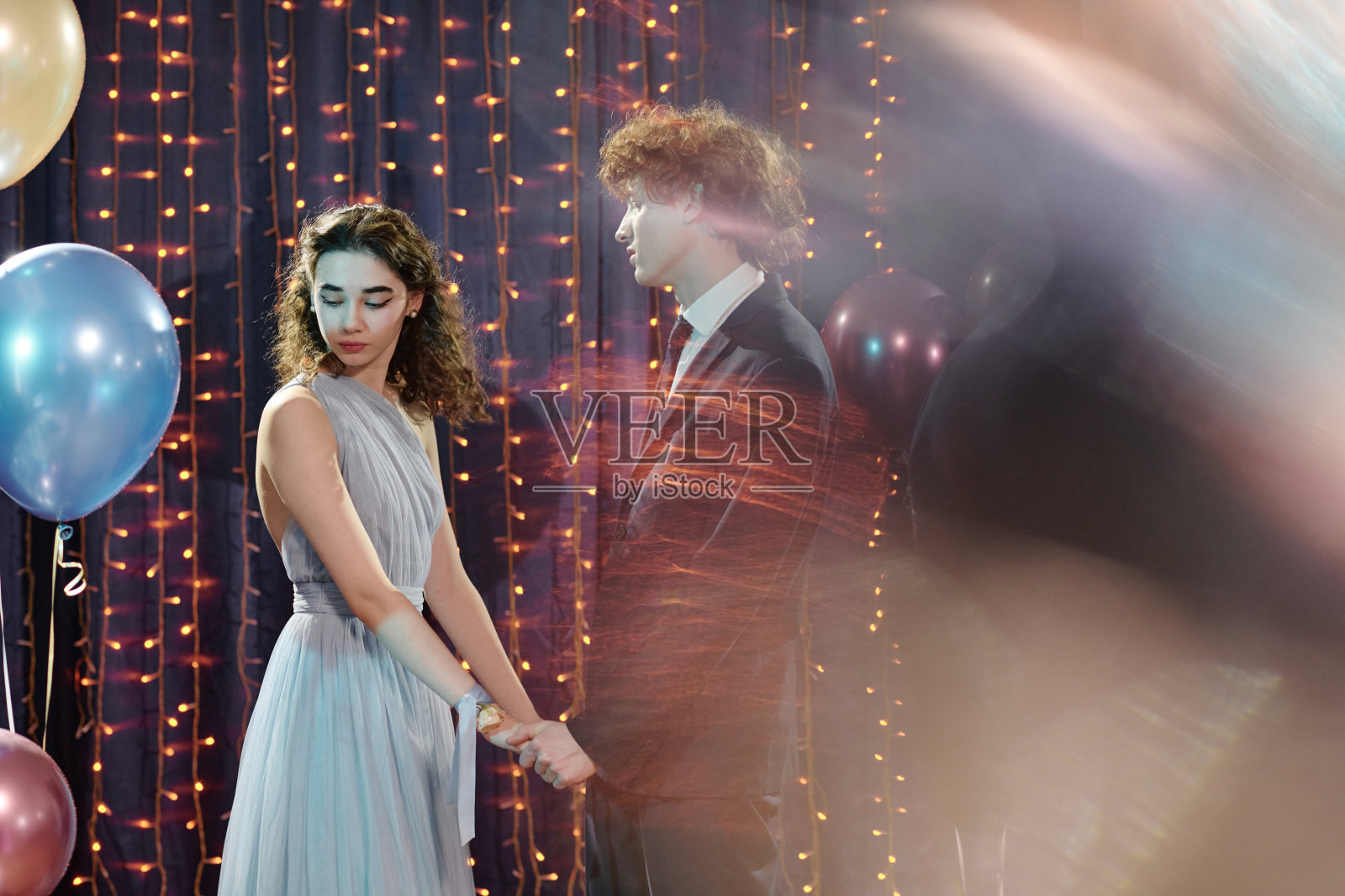 舞会上手牵手的白人少女与白人少年照片摄影图片