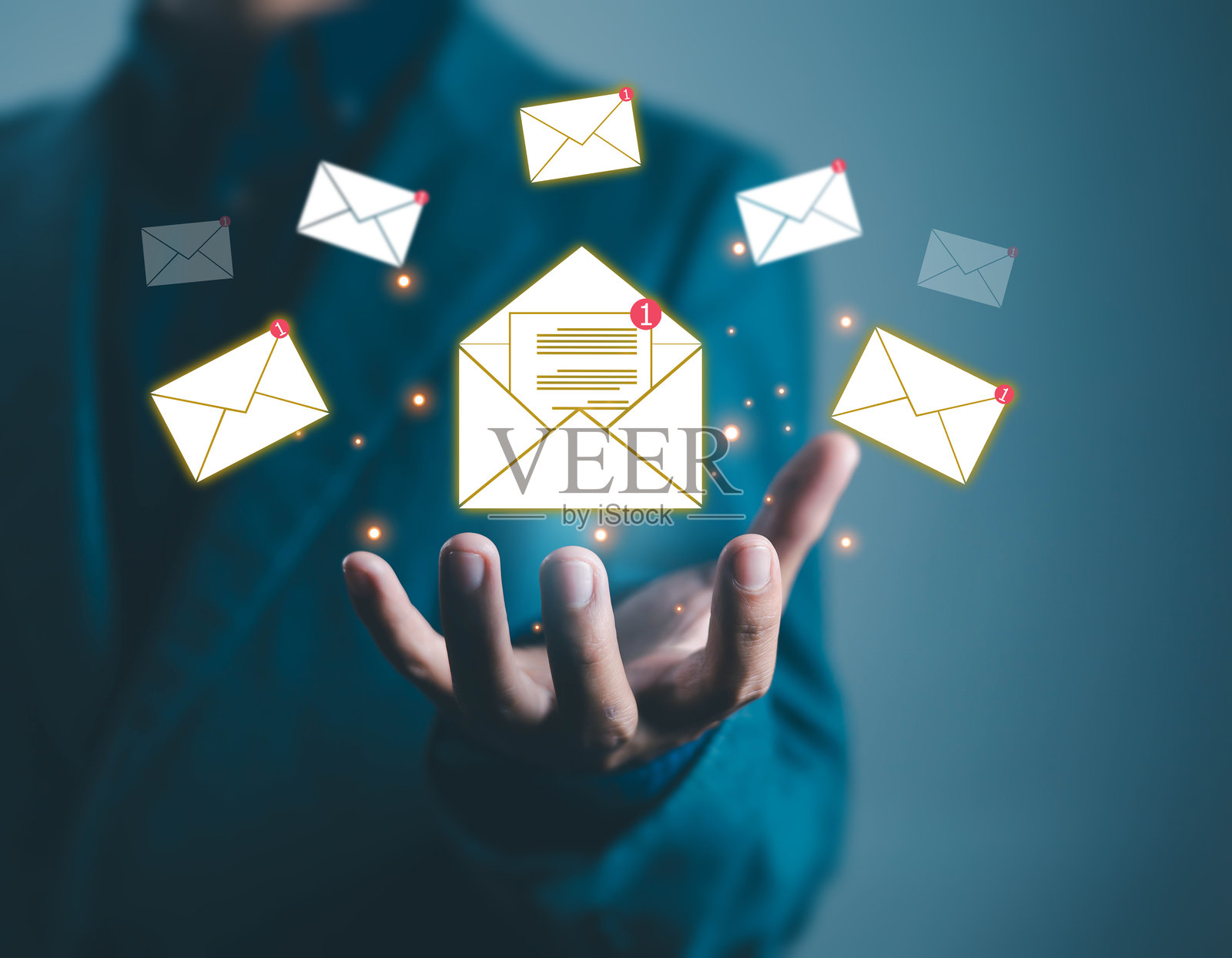 商人手中握着数字邮件图标,带有新消息通知,象征着在线沟通、电子邮件营销、客户服务和现代商业科技。照片摄影图片
