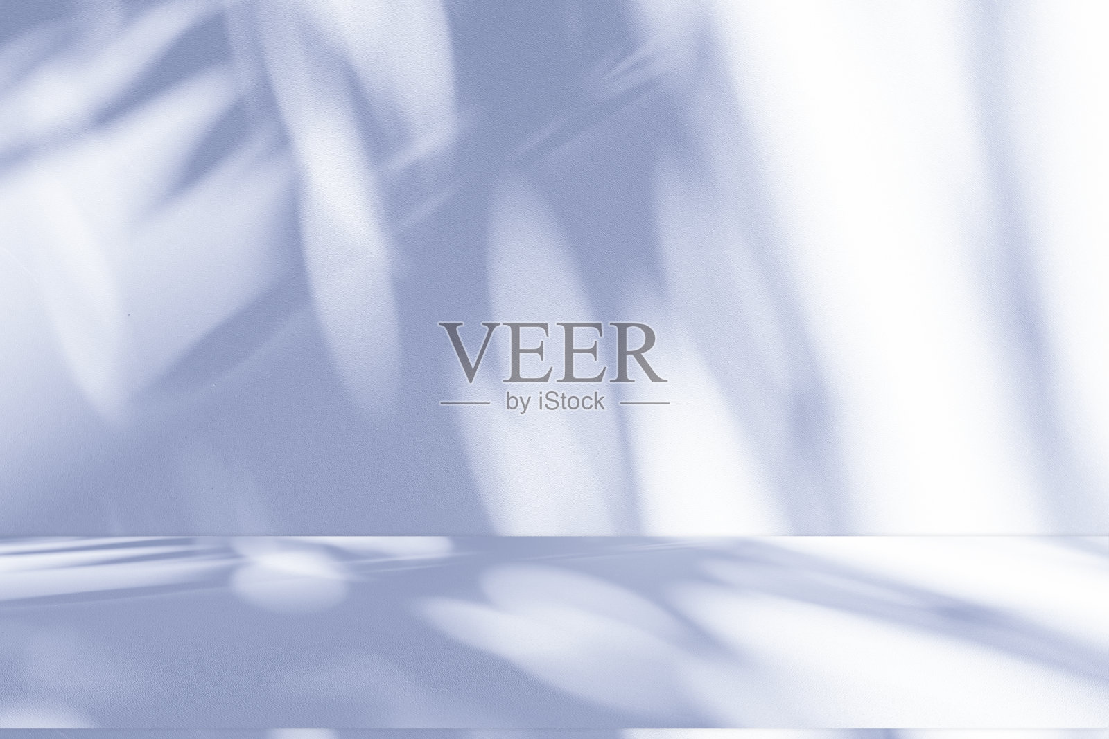 工作室风格的背景墙装饰呈现采用白色和蓝色调。阴影从附近的窗户投射出来,创造了一个装饰性的概念照片摄影图片