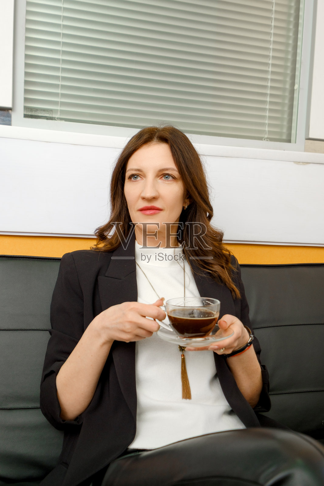 一位女性在现代办公室享受下午茶时间的咖啡照片摄影图片