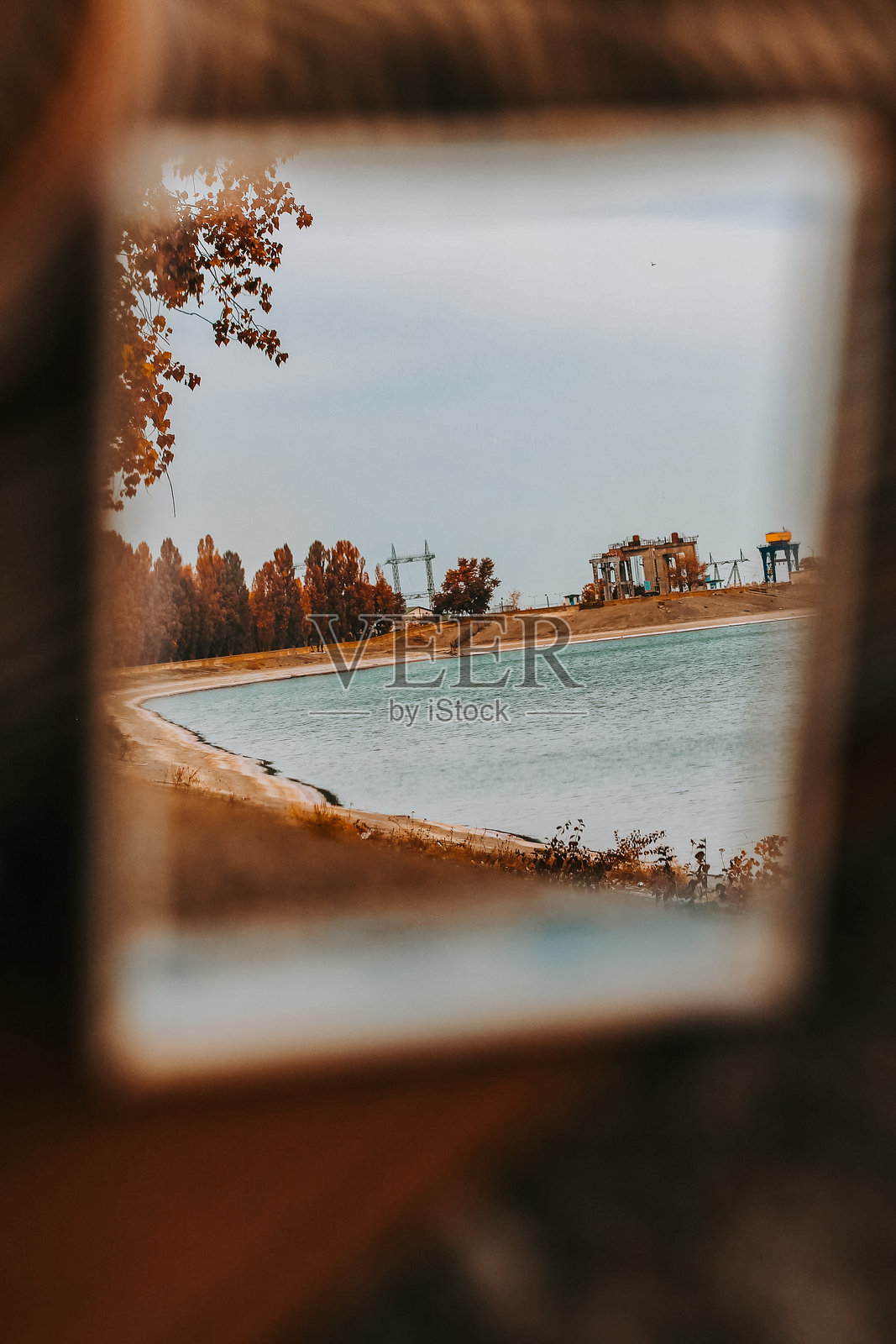 秋季湖泊风景框架。秋季公园和河流的倒影。湖泊和秋天的树木在阴云密布的天空下展现出温暖的季节色彩。照片摄影图片