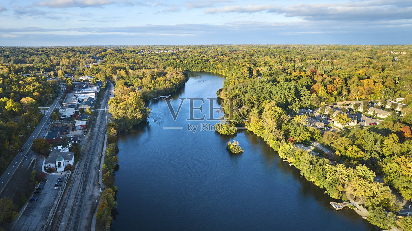 俯瞰小镇上宁静的河流和秋天的树木照片摄影图片