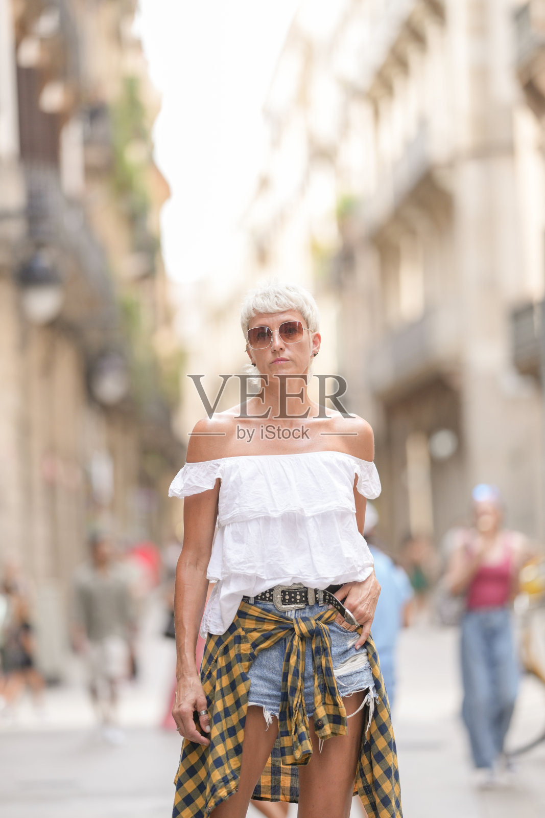 一位穿着白衬衫和蓝牛仔裤的女性正在街上行走照片摄影图片