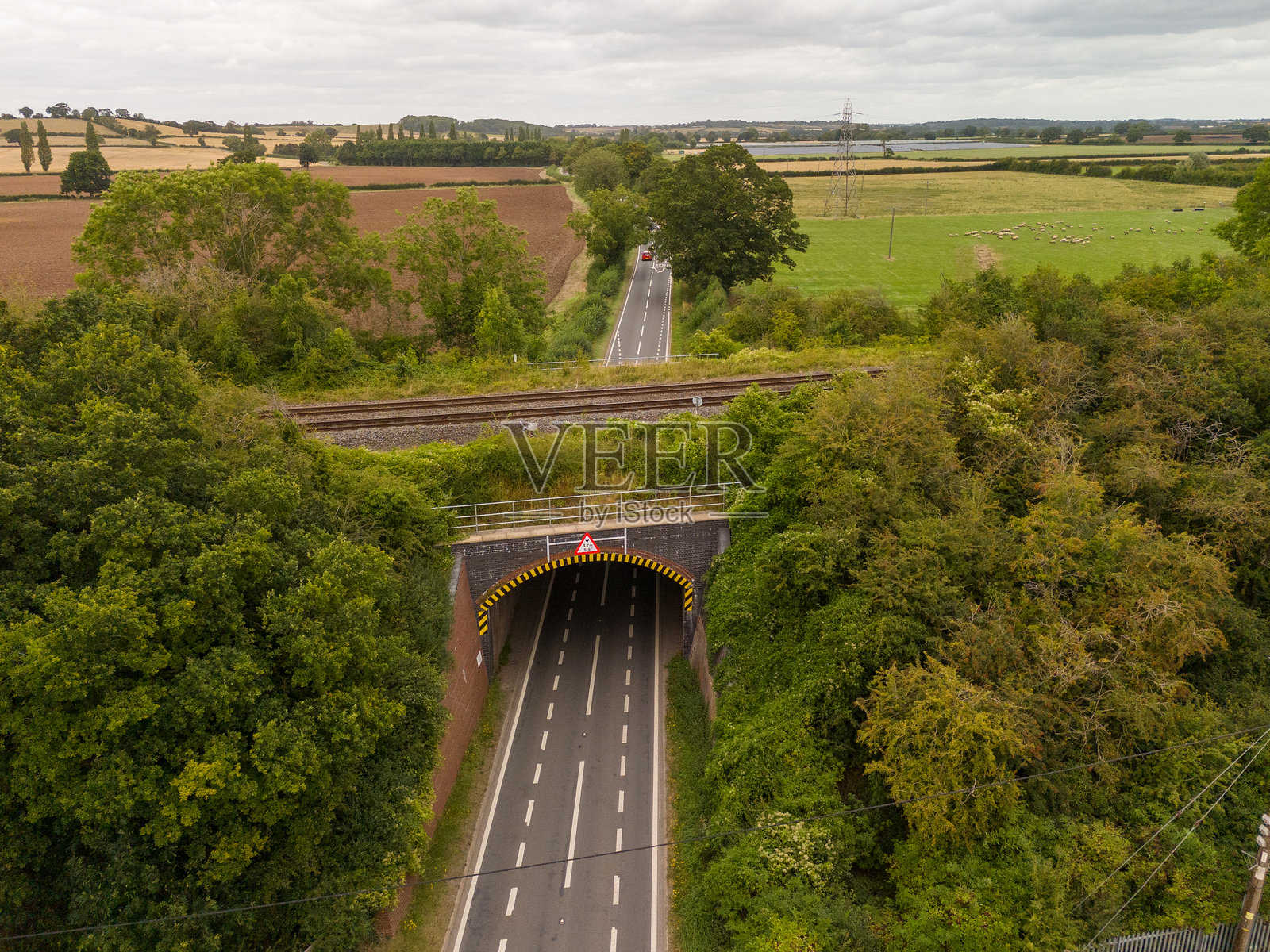 英国乡村铁路桥下的乡村公路鸟瞰图照片摄影图片