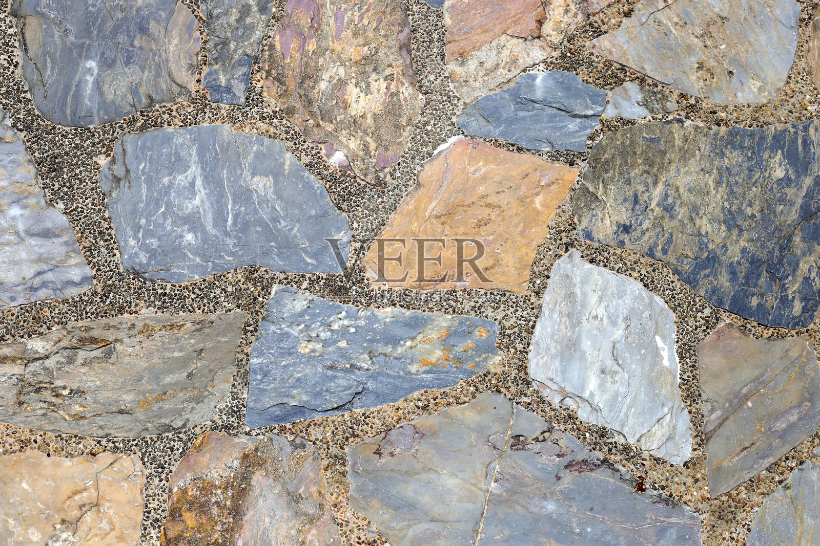 用混凝土铺设的不规则天然石块装饰性石材路面。照片摄影图片