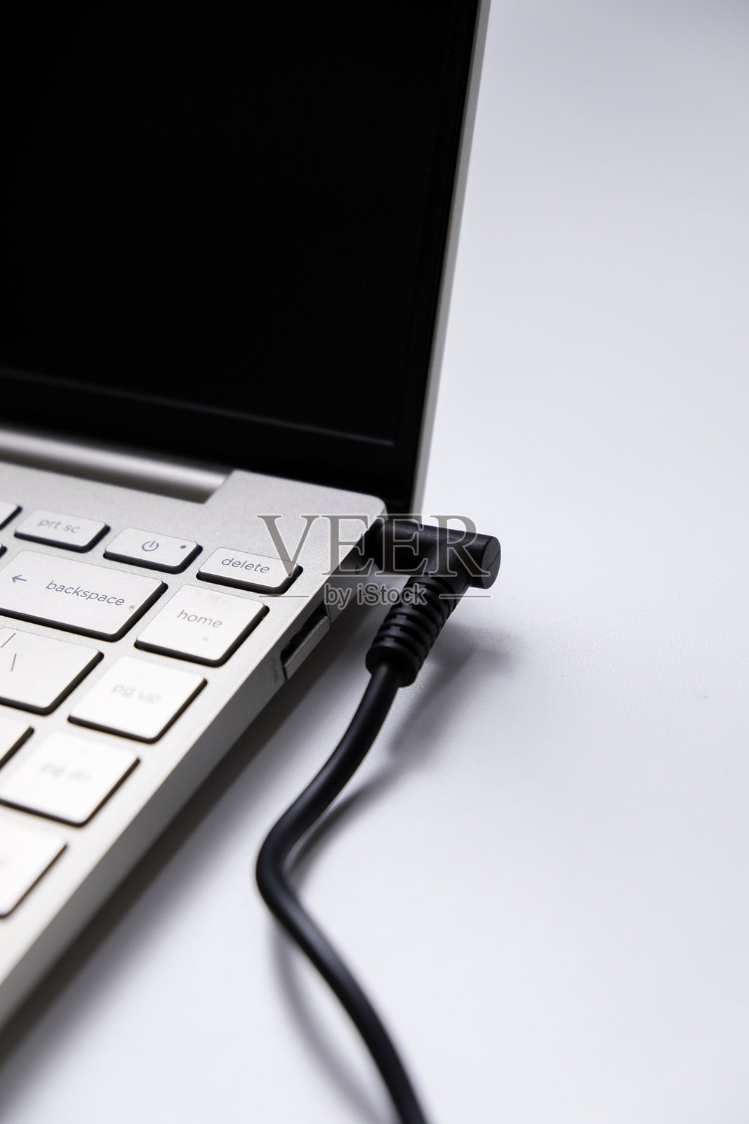 在白色背景上,孤立的电源适配器为笔记本电脑充电照片摄影图片