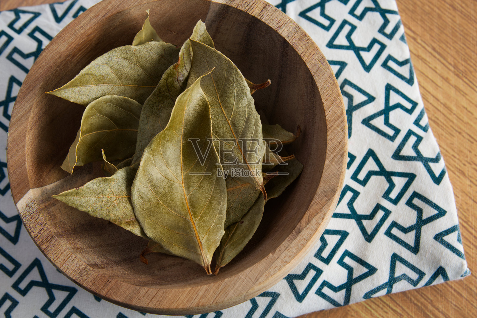 桌子上的木碗里装着干月桂叶照片摄影图片